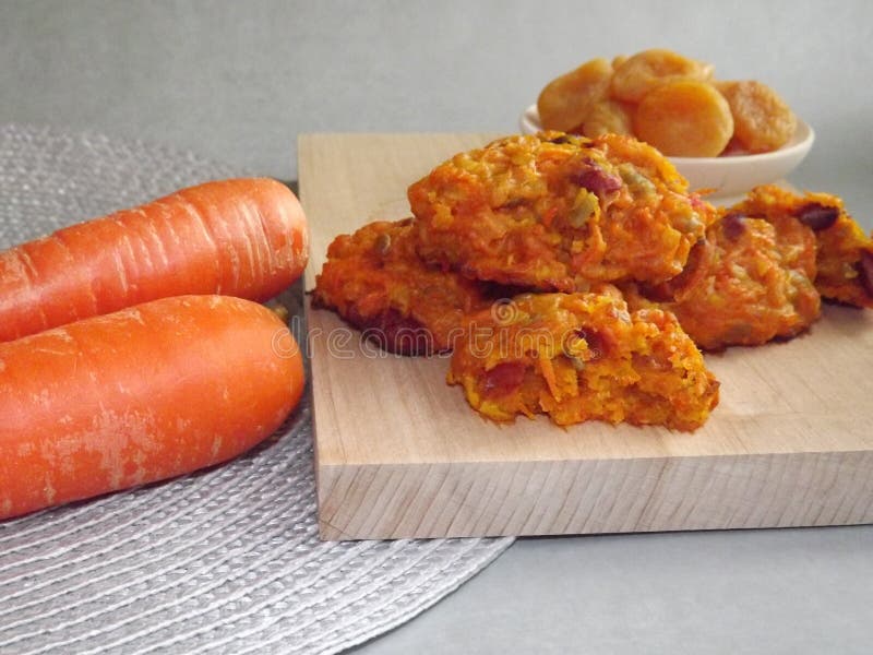 The process of making carrot cookies with the addition of dried apricots, peanuts and sunflower seeds on a silver