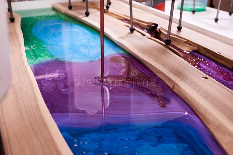 Process Making of a Craft Resin and Wood Table. Liquid Epoxy is Poured into a Mold with Wooden