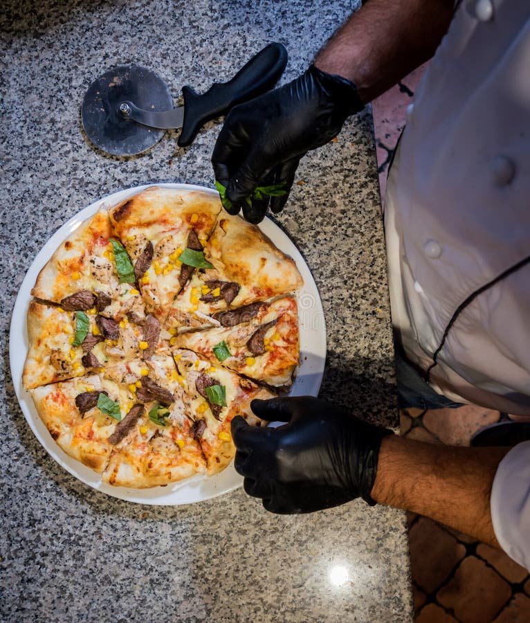 The Process of Making Pizza. Hands of Chef Baker Making Pizza at Cafe
