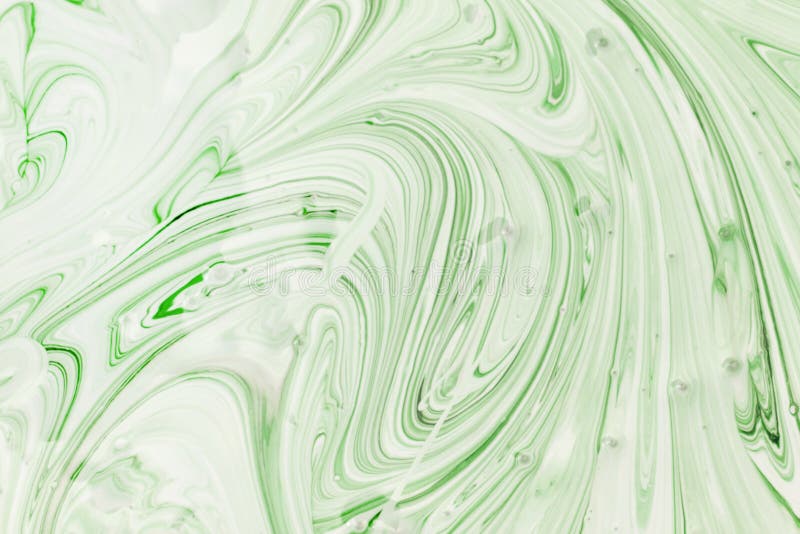 The Process Of Mixing White And Light Green Paint Closeup. Abstract