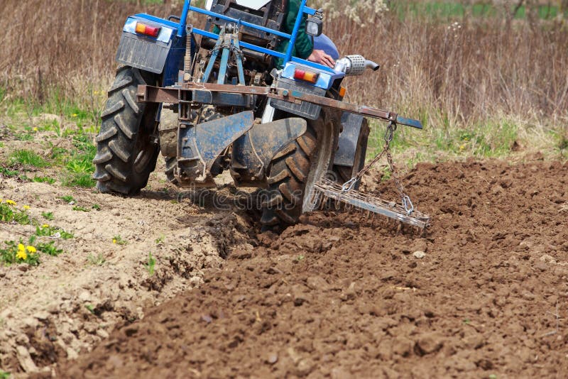 Man Plowing the Land in the Garden on Sky Background Stock Image
