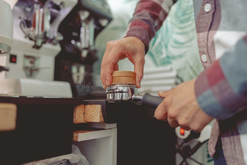 Close Up of Barista Tamping Ground Coffee for Making Espresso Stock