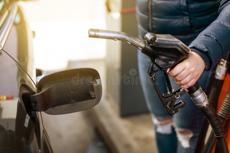 Process of refueling a car fill with petrol fuel at the gas station, pump filling fuel nozzle in fuel tank of car, high