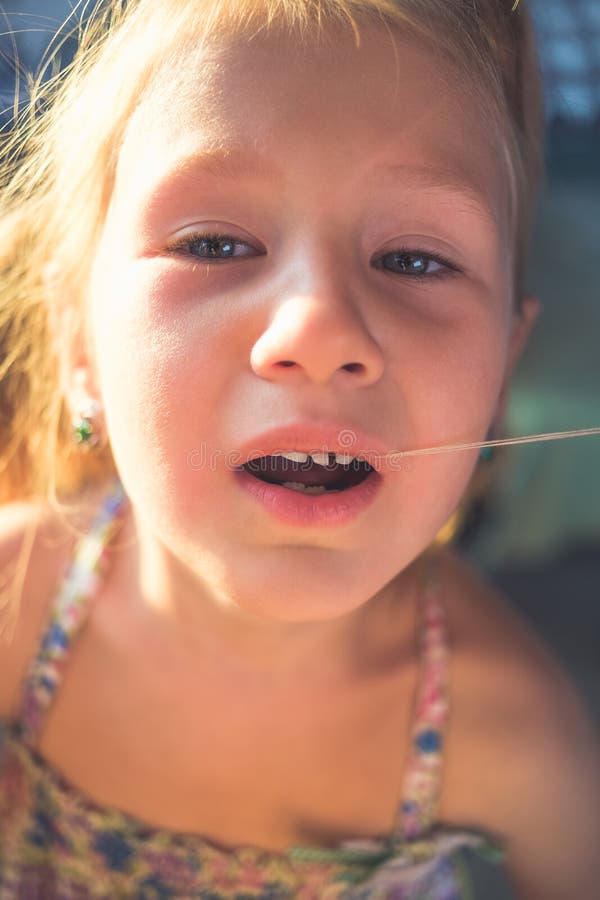 The Process of Removing a Baby Tooth Using a Thread Stock Photo Image