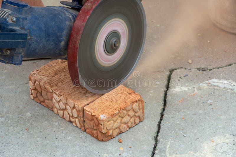 The Process of Sawing Bricks with a Grinder with a Diamond Disc Stock