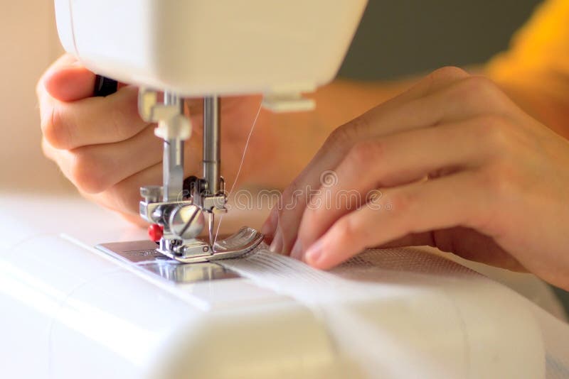 The Process of Sewing Curtains from a Mesh of White Fabric. Close Up