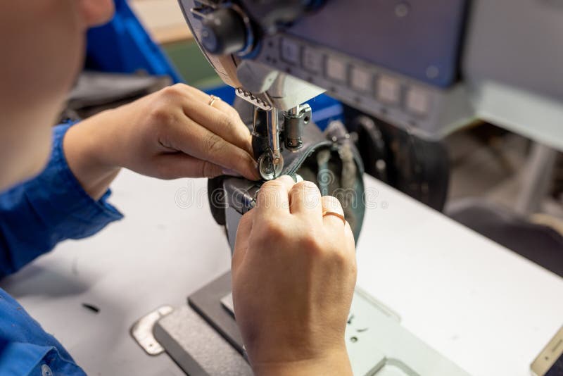 The Process of Sewing Shoes on a Sewing Machine. Shoe Production Stock