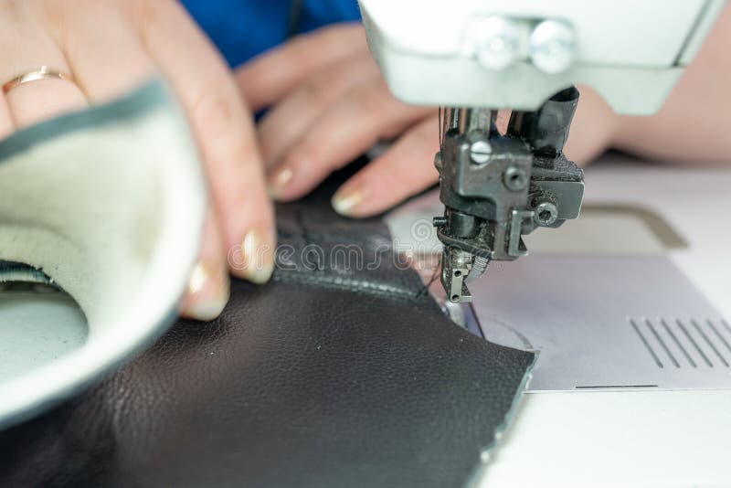 The Process of Sewing Shoes on a Sewing Machine. Shoe Production Stock