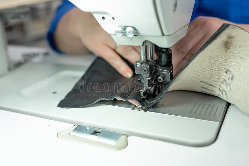 The Process of Sewing Shoes on a Sewing Machine. Shoe Production Stock
