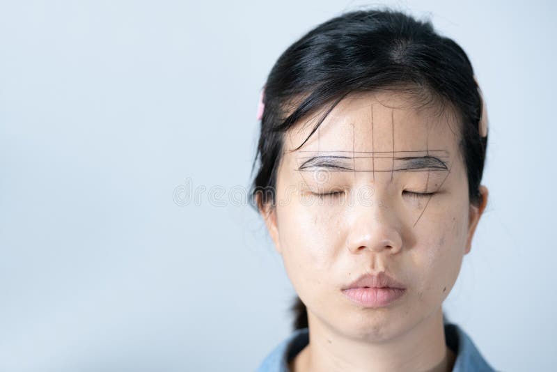 The Process of Shaping Eyebrows by a Beauty Master with a Thread for a