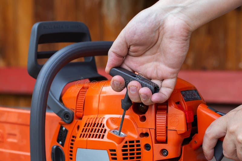 The process of starting a chainsaw. A male worker pulls the starting cable of a chainsaw with his hand. Close-up stock images