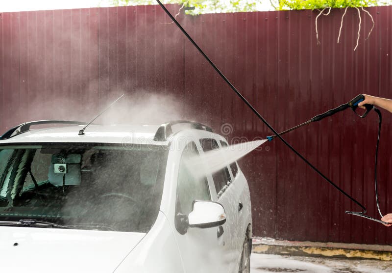 The Process of Washing a White Car Using a Pressure Washer Stock Image