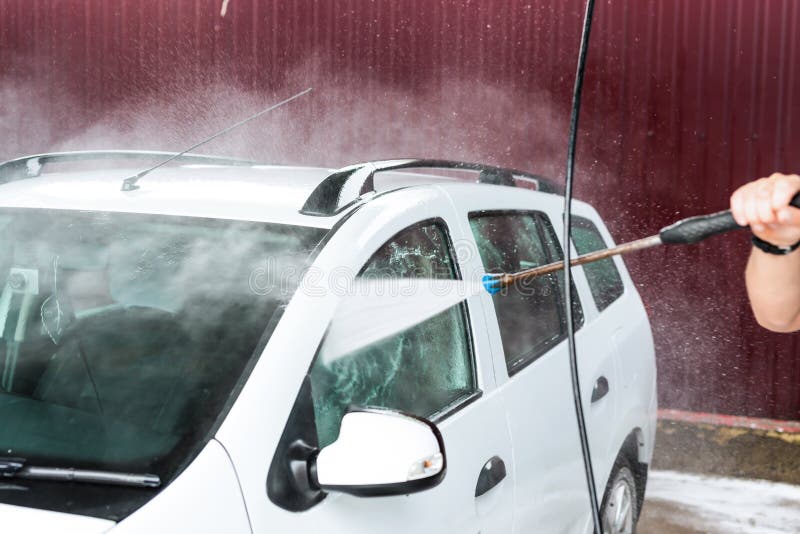 The Process of Washing a White Car Using a Pressure Washer Stock Photo