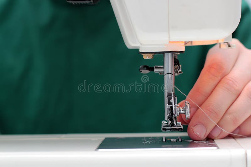 Processes of sewing Linum on the sewing machine sew women`s hands sewing machine Linum. sewing machine and female fingers out of stock photography Processes of sewing Linum on the sewing machine sew women`s hands sewing machine Linum. sewing machine and female fingers out of stock photography