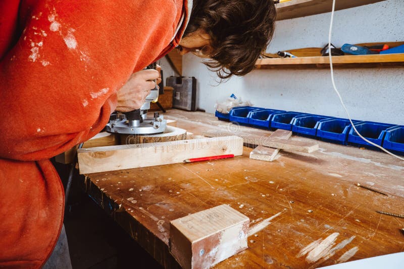 Processing of a furniture part by a machine for polishing a tree. the grinding machine on a board, selective focus. royalty free stock photography