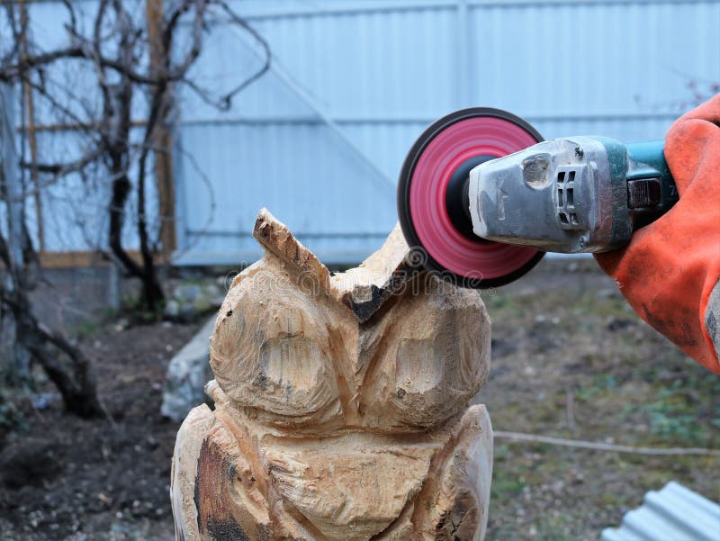 Grinding with sandpaper on a grinder of a wooden statue of a bird royalty free stock photography