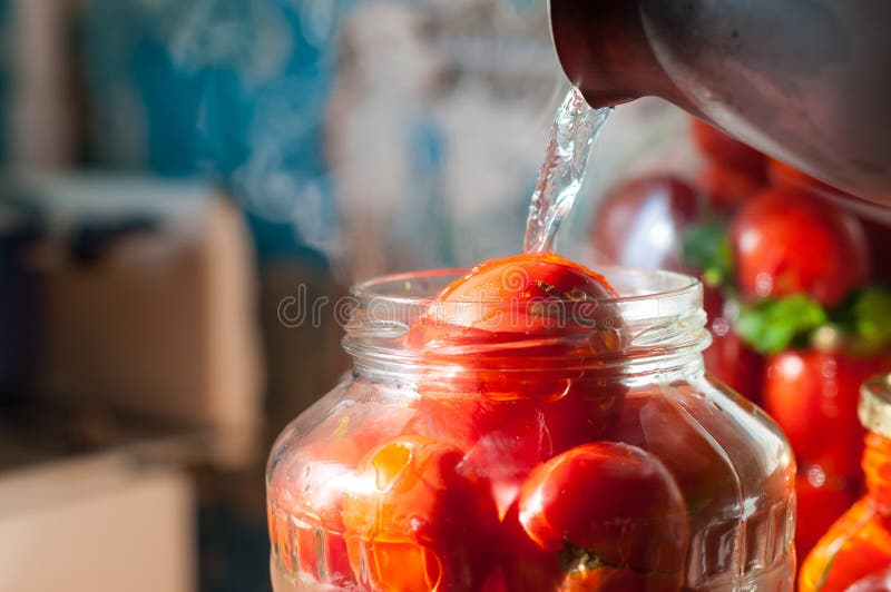 Processo de colocação em latas de tomate no frasco de pedreiro Em fotografia de stock Processo de colocação em latas de tomate no frasco de pedreiro Em fotografia de stock