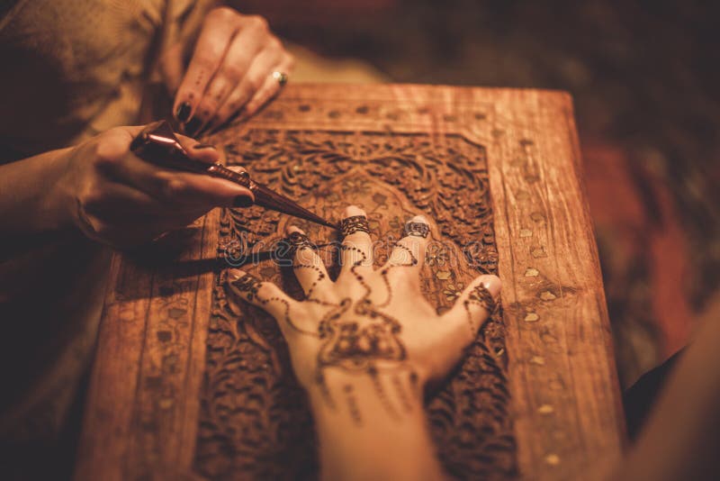 Drawing process of henna menhdi ornament on woman's hand. Drawing process of henna menhdi ornament on woman's hand