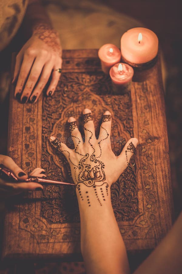 Drawing process of henna menhdi ornament on woman's hand. Drawing process of henna menhdi ornament on woman's hand