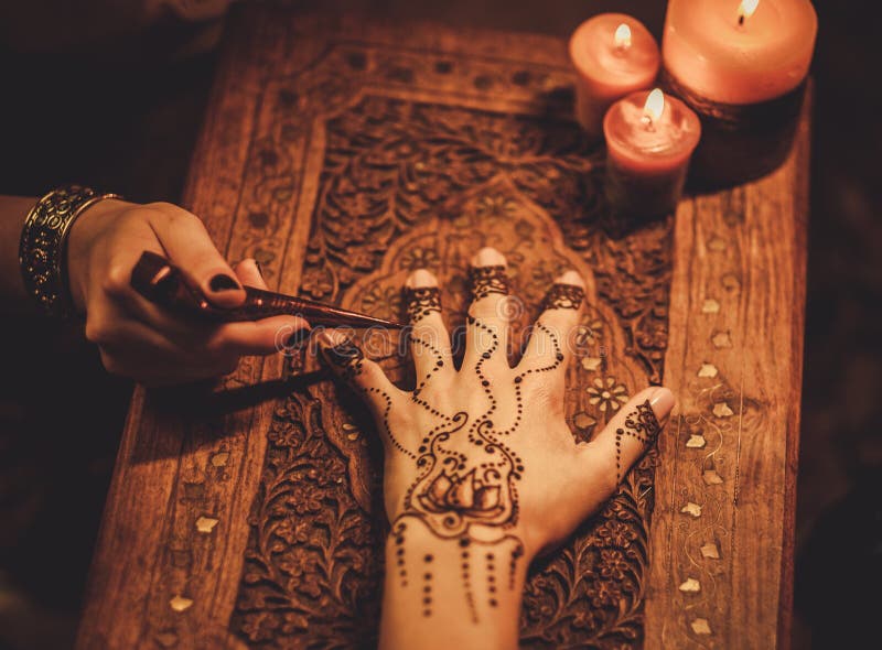 Drawing process of henna menhdi ornament on woman's hand. Drawing process of henna menhdi ornament on woman's hand