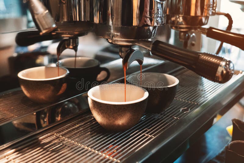 Processus de faire deux tasses de la boisson de café en même temps utilisant la machine professionnelle de café en café images stock Processus de faire deux tasses de la boisson de café en même temps utilisant la machine professionnelle de café en café images stock