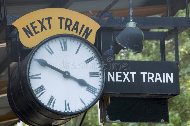An antique clock shows the time of the next train departure at an old train station. An antique clock shows the time of the next train departure at an old train station