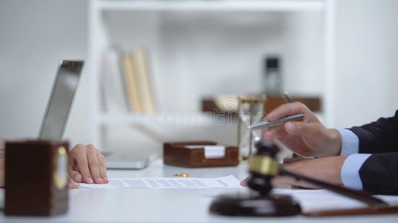 Procurador que muestra a la mujer dÃ³nde firmar el documento de divorcio, consulta legal