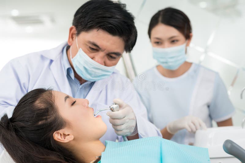 Professional team of a dentist and his assistant performing a dental procedure. Professional team of a dentist and his assistant performing a dental procedure