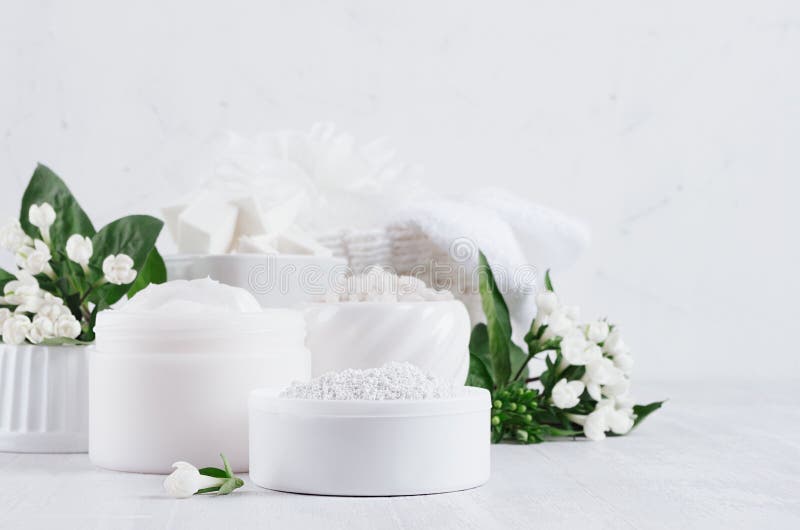 Prodotti delicati dei cosmetici della luce di eleganza per cura di pelle e del corpo con i fiori bianchi e le foglie verdi fresch immagine stock Prodotti delicati dei cosmetici della luce di eleganza per cura di pelle e del corpo con i fiori bianchi e le foglie verdi fresch immagine stock