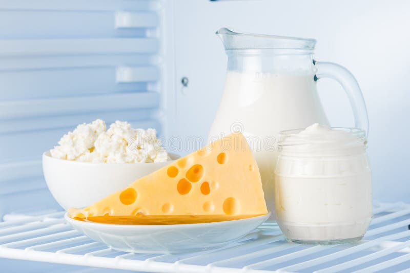 Tasty healthy dairy products in the refrigerator: sour cream in the bank, cottage cheese in bowl, cheese and milk in a jar. Tasty healthy dairy products in the refrigerator: sour cream in the bank, cottage cheese in bowl, cheese and milk in a jar