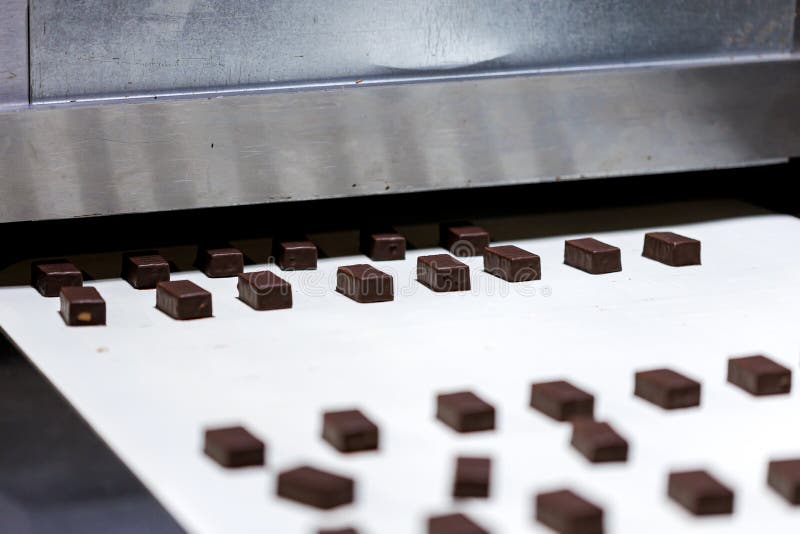 Production of Chocolate Candy. Sweets on Conveyor Belt at Factory Stock