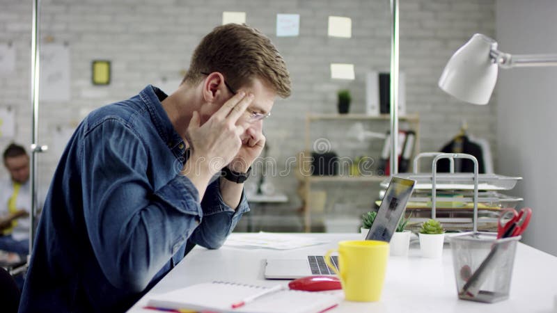 Produktiver Geschäftsmann, der zurück Fertigungsbüroarbeit auf Laptop, effektiver Manager zufrieden gewesen mit Sitzungsfrist leh