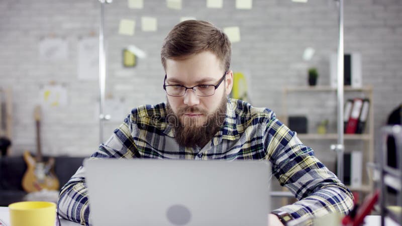 Produktiver organisierter Geschäftsmann, der zurück Fertigungsbüroarbeit auf Laptop, effektiver Manager zufrieden gewesen mit Sit