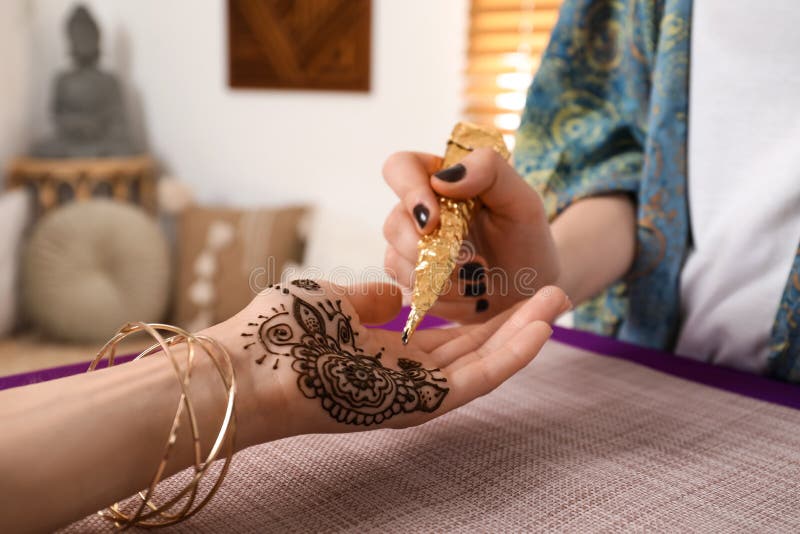 Profesjonalny mistrz mehndi robiący tatuaż henny w zamknięciu domów