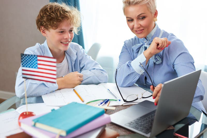 Profesoară de engleză caucaziană ajută băiatul să învețe lecții acasă stock photos