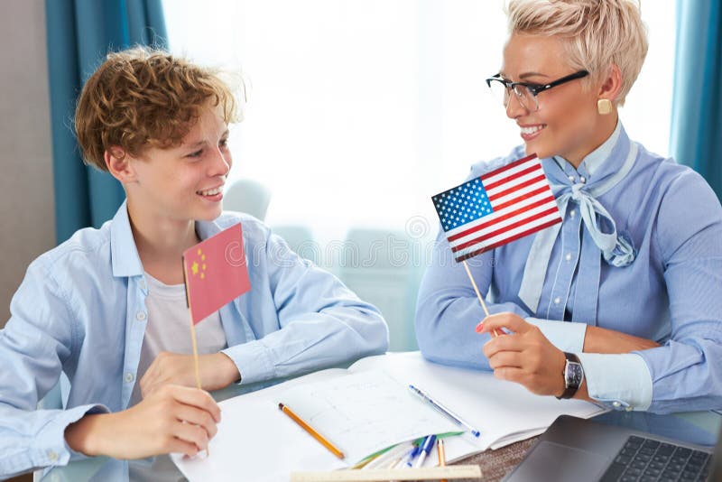 Profesoară de engleză caucaziană ajută băiatul să învețe lecții acasă stock images