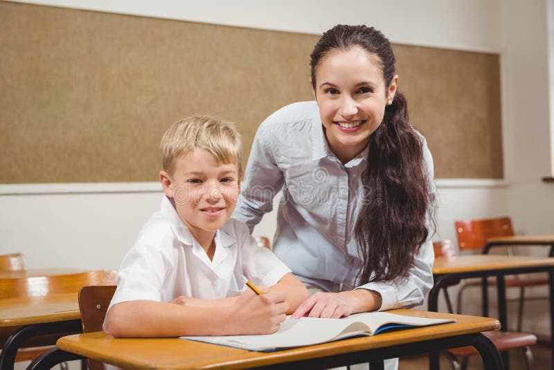 Profesor care ajută un elev din clasă stock photo