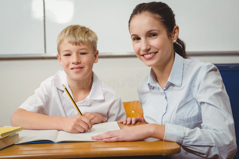 Profesor care ajută un elev din clasă stock photo