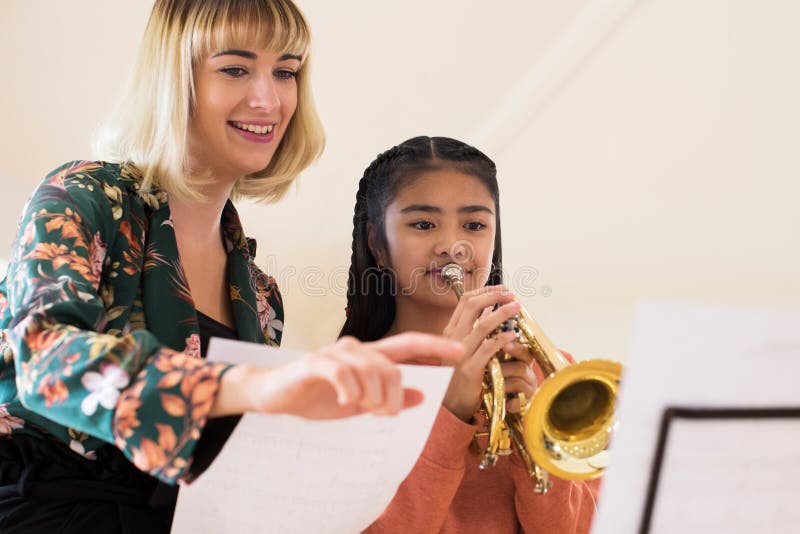 Profesor Helping Female Student para tocar la trompeta en la lección de música imágenes de archivo libres de regalías Profesor Helping Female Student para tocar la trompeta en la lección de música imágenes de archivo libres de regalías