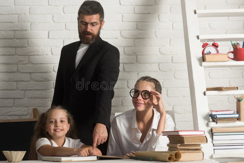 Profesor que estudia los libros de escuela en clase con los niños de la escuela primaria fotografía de archivo libre de regalías Profesor que estudia los libros de escuela en clase con los niños de la escuela primaria fotografía de archivo libre de regalías