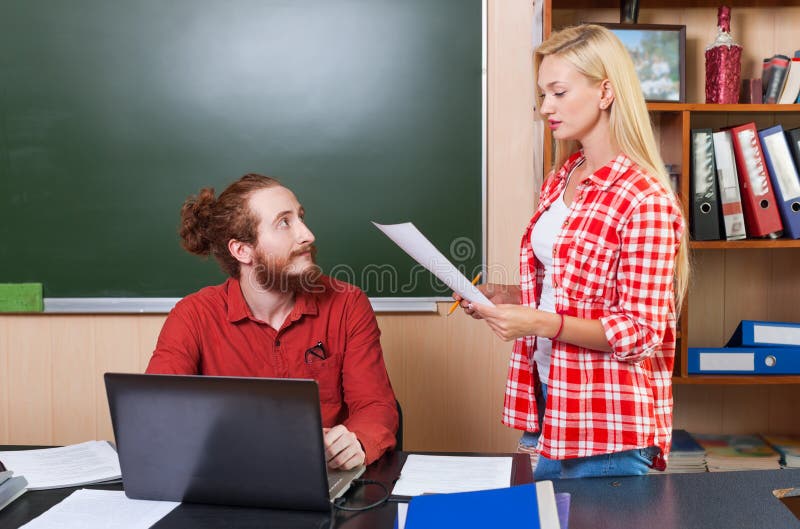 Profesor Używa laptop Patrzeje Młodego Studenckiego dziewczyna chwyta papieru prześcieradeł dokumentu raport, Uniwersytecki naucz zdjęcie stock Profesor Używa laptop Patrzeje Młodego Studenckiego dziewczyna chwyta papieru prześcieradeł dokumentu raport, Uniwersytecki naucz zdjęcie stock