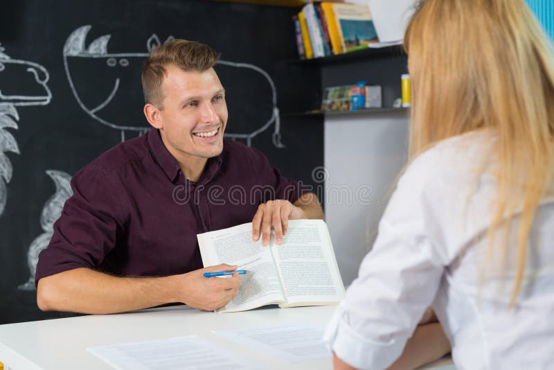 Profesora y madre de sexo masculino discutiendo en aula. mamá en reunión de padres de profesores en kindergarten imágenes de archivo libres de regalías Profesora y madre de sexo masculino discutiendo en aula. mamá en reunión de padres de profesores en kindergarten imágenes de archivo libres de regalías