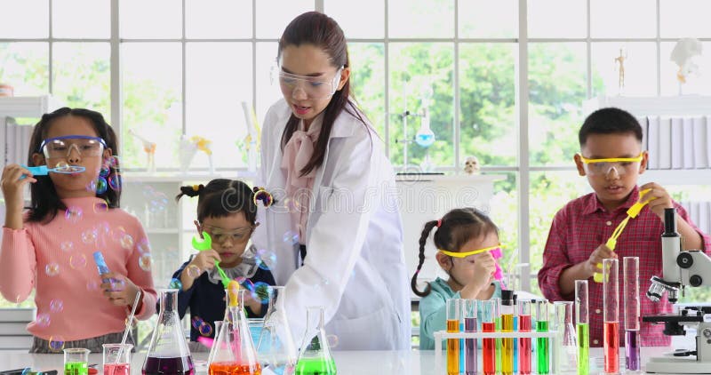 Professeur asiatique et étudiants soufflant des bulles dans le laboratoire banque de vidéos