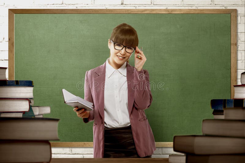 Professeur féminin asiatique de sourire prêt à enseigner image libre de droits Professeur féminin asiatique de sourire prêt à enseigner image libre de droits