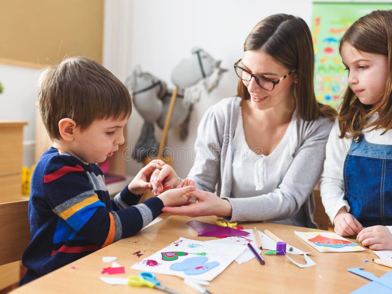Professeur préscolaire avec des enfants au jardin d'enfants - Art Class créatif images stock Professeur préscolaire avec des enfants au jardin d'enfants - Art Class créatif images stock