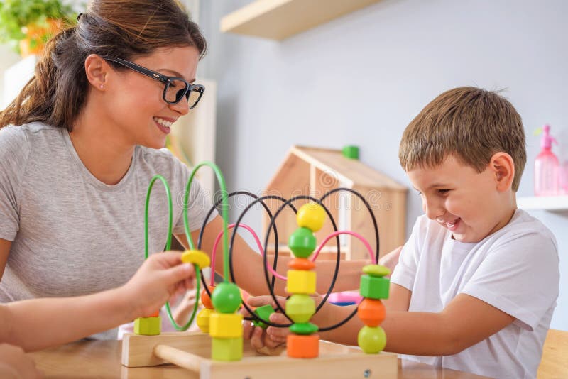 Professeur préscolaire avec des enfants jouant avec les jouets didactiques colorés au jardin d'enfants photos libres de droits Professeur préscolaire avec des enfants jouant avec les jouets didactiques colorés au jardin d'enfants photos libres de droits