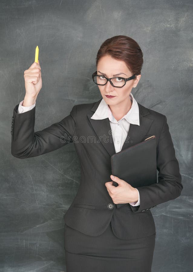Enseignant(e) strict(e) avec craie et dossier photo libre de droits