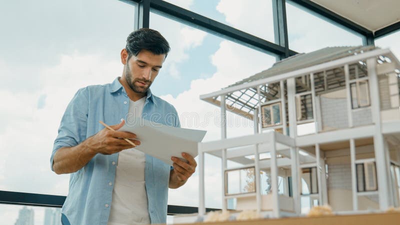 Professional architect comparing between blueprint house model. Tracery royalty free stock photography