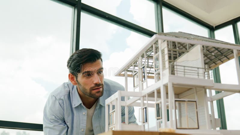 Professional architect comparing between blueprint house model. Tracery stock photography