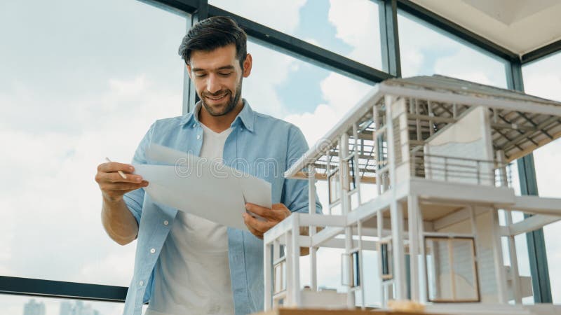 Professional architect comparing between blueprint house model. Tracery royalty free stock photography